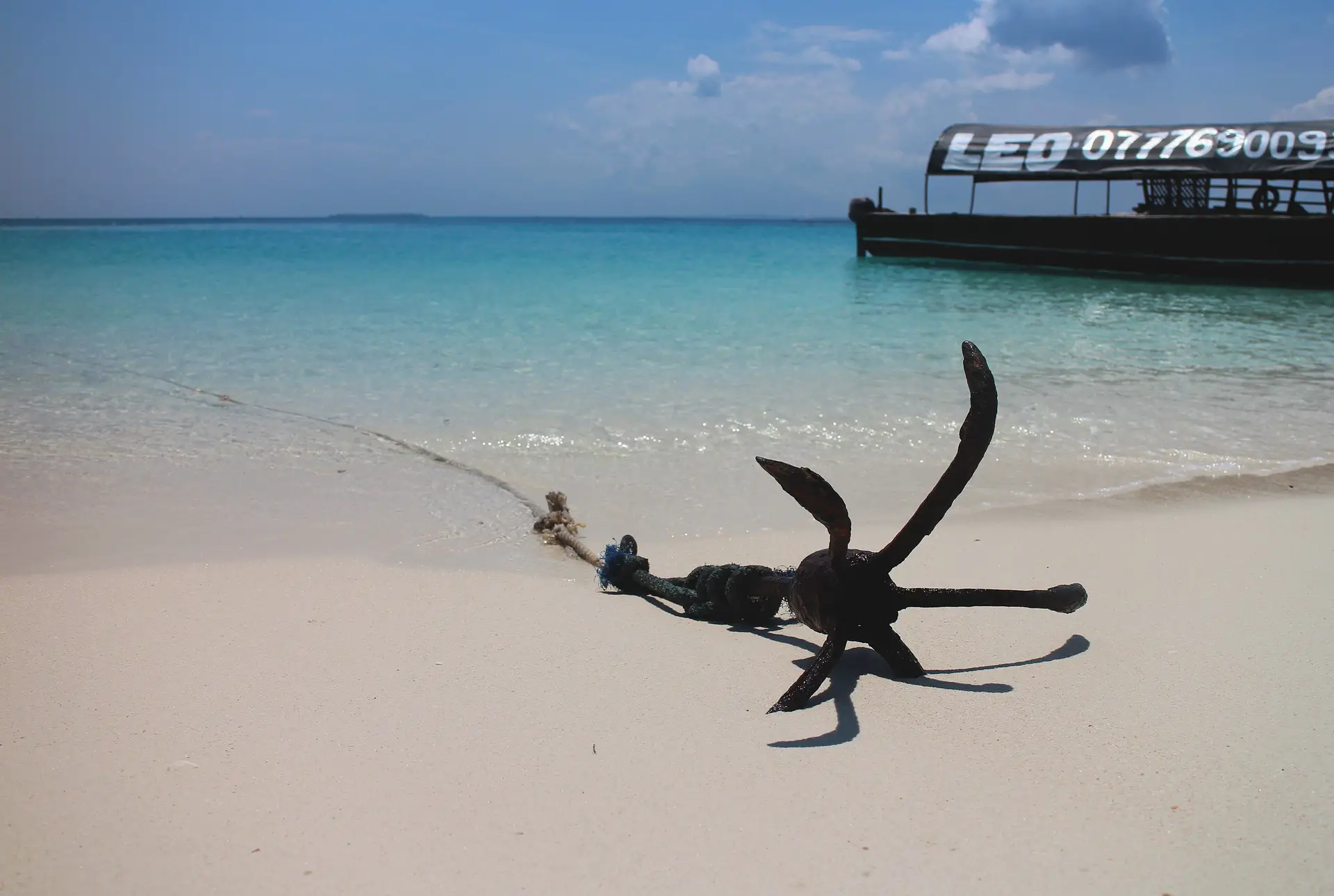 An anchor is deployed from a boat to a sandbar