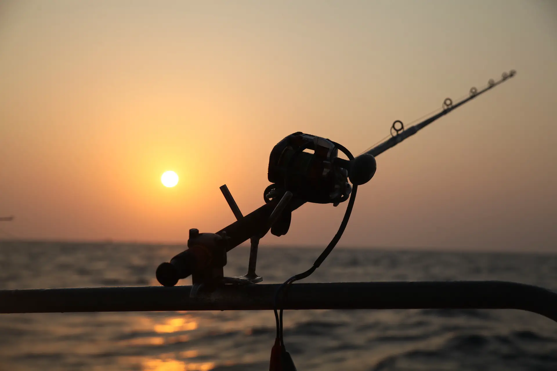 A fishing reel mounted to the railing of a boat