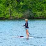 Person standup paddleboarding on a lake