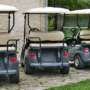 A row of parked electric golf carts