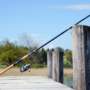 A fishing rod resting on a dock piling