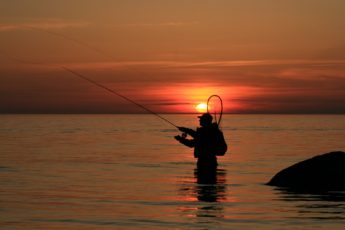 An angler casting at sunset