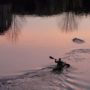 A kayaker paddling at sunset