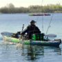 An angler paddling a kayak designed for fishing