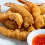 A plate of fried shrimp with dipping sauce