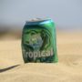 A beer can supported by the sand on a beach