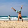 A person doing a handstand at the beach